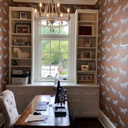 An office with horse wallpaper on it.